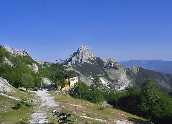Il Rifugio Orto di Donna, sullo sfondo il Pizzo d'Uccello.