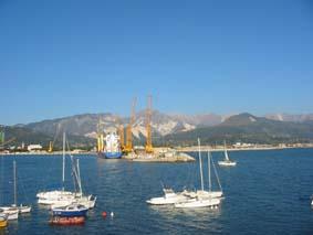 dal porto di Marina di Carrara: la Brugiana è a dx sfregiata dalle cave, più dietro le Apuane con al centro il monte Sagro