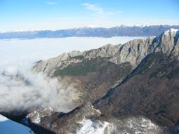 la cresta di Nattapiana tra il mare di nuvole, vista dalla vetta del Sagro, il paese di Vinca è nascosto dalle nuvole in primo piano