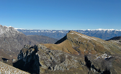 il M. Croce con la prima neve visto dalla vetta del M. Nona, sullo sfondo l’Appennino, a sinistra la Pania Secca. In basso al centro (segno nero) la gola delle Scalette